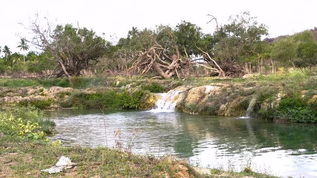 Blue water water with small waterfall up in the mountains of Salalah, Oman in May.