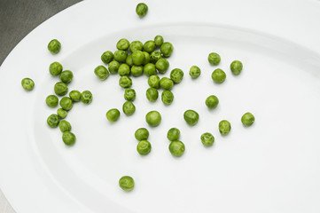 Plate filled with peas on a metal kitchen table