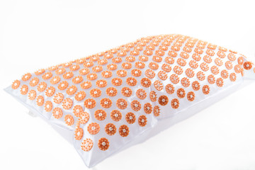 Acupuncture orthopedic massage mat with needles and spikes for feet and body isolated on white background. Alternative medicine, health care, recreation and muscle relaxation concept.