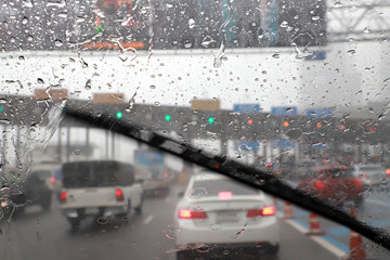 Front view of Driving with car windshield wipers in raining day on the expressway tollgate