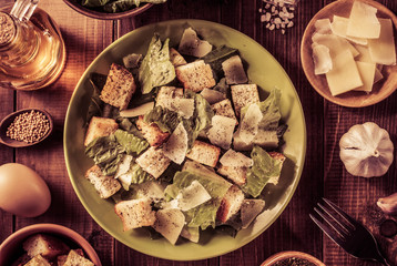 caesar salad and ingredients at wood