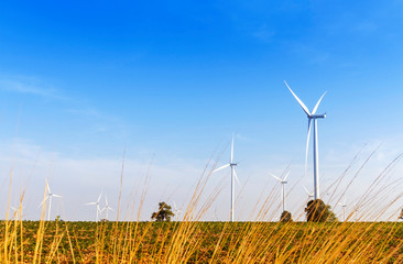 Wind turbines electric power generator on blue sky at agriculture field