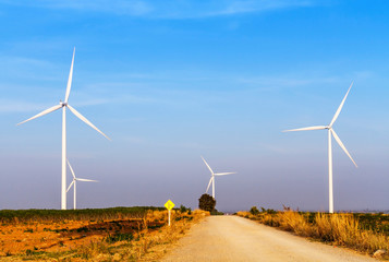 Wind turbines electric power generator on blue sky at agriculture field