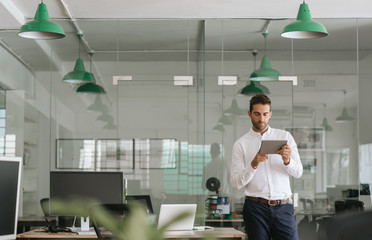 Focused young businessman working on a tablet in an office