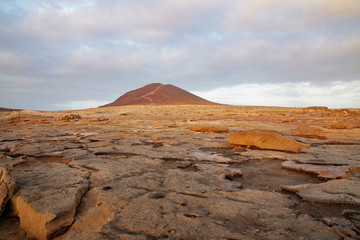 Overcast sunrise over Montana Roja Special Natural Reserve, an unusual volcanic cone, one of the best samples of inorganic sand habitats on the island, in El Medano, Tenerife, Canary Islands, Spain