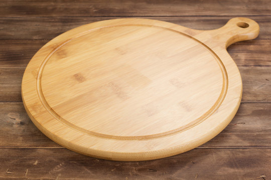 pizza cutting board at rustic wooden table in front