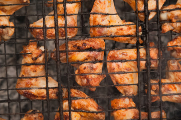Kebabs chicken wings on the grill with smoke close-up. Chunks of chicken barbecue on the fire. Backyard, concept of rest, meat, summer, copy space.