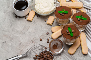 Frame made of Classic tiramisu dessert in a glass and savoiardi cookies on concrete background