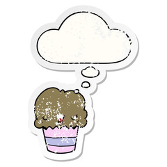 cartoon cupcake with face and thought bubble as a distressed worn sticker