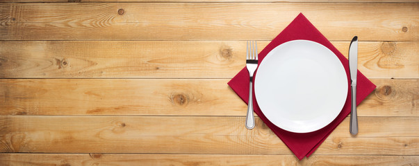 plate, knife and fork at wooden  background