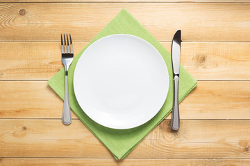 plate, knife and fork at wooden  background