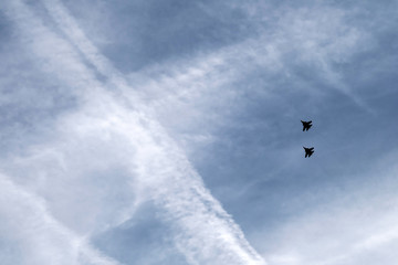 silhouettes of fighters are flying in the sky