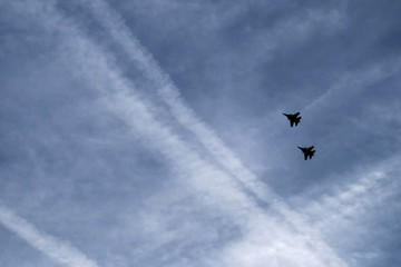 silhouettes of fighters are flying in the sky