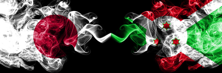 Japan vs Burundi, Burundian smoky mystic flags placed side by side. Thick colored silky smokes combination of Burundi, Burundian and Japanese flag