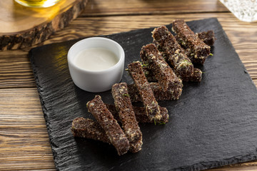 Rye bread croutons with garlic, oil and salt on stone board on wooden table