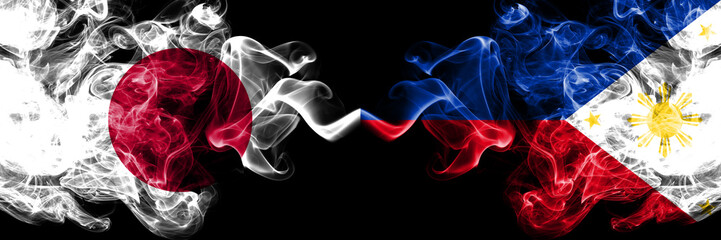 Japan vs Philippines, Filipino smoky mystic flags placed side by side. Thick colored silky smokes combination of Philippines, Filipino and Japanese flag