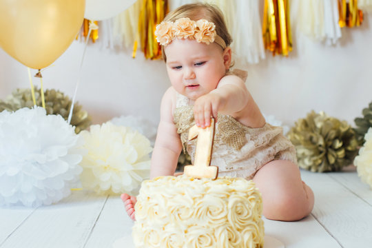 Little baby girl eating cake on her first birthday cakesmash party 