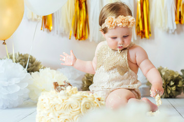 Little baby girl eating cake on her first birthday cakesmash party 