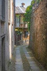 narrow medieval cobblestone alley on the island of San Giulio. Orta Lake, Italy