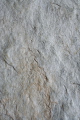 A surface of a architectural stone.(white, gray and brown. rough)