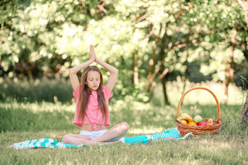 Obraz na płótnie Canvas Little girl in yoga position in the park.