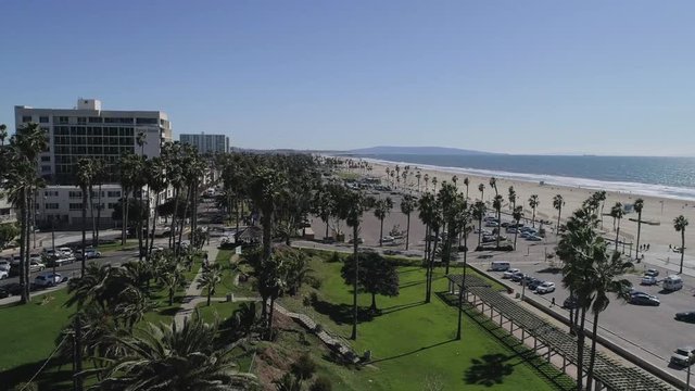An aerial reveal of Santa Monica Beach, shorelines in Sunny California with a Rise and Rotate movement - 1080P 30P
