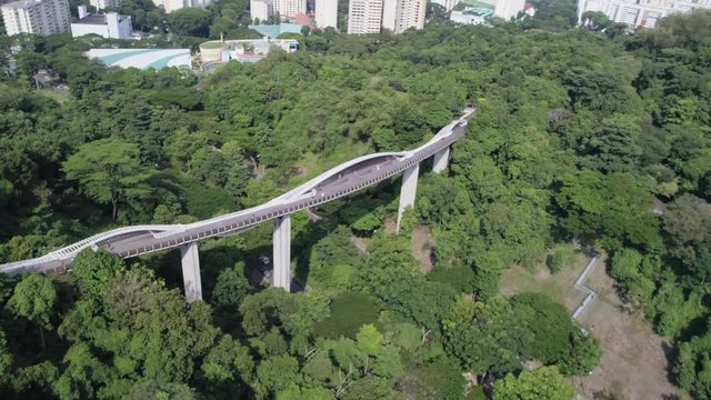 Aerial Shot of the Henderson Wave Bridge amongst the lush greenery of the South East Asian City State Singapore in 1080P 24P