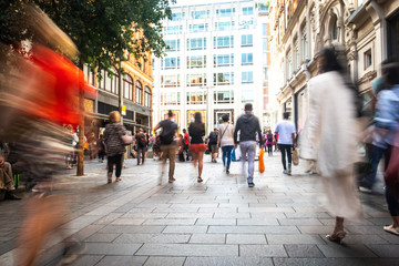 Motion blurred people on shopping street - obrazy, fototapety, plakaty