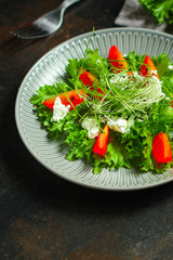 salad with tomato, lettuce, arugula and other green leaves. food background. top