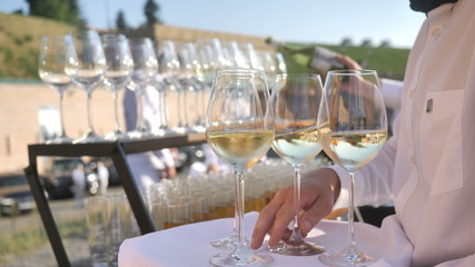 Catering service.The waiter pours red Italian and french wine from a traditional grape variety, collected and made by the farmer for craft winemaking
