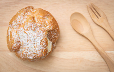 Choux  cream on a wooden tray and have a wooden cutlery placed, Top view.