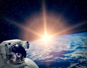Obraz na płótnie Canvas Astronaut looking at sunrise. The elements of this image furnished by NASA.