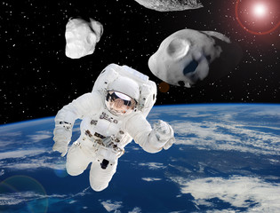 Astronaut and asteroids above earth. The elements of this image furnished by NASA.