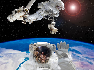 Astronaut waving. Other astronaut on the backdrop. Space scene. The elements of this image...