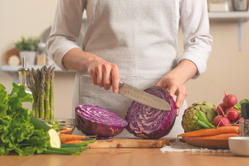 The chef cuts, chops fresh purple lettuce salad. The concept of losing healthy and wholesome food, detox, vegan eating, diet, cooking. Slow food, comfort food, healthy diet, clean eating