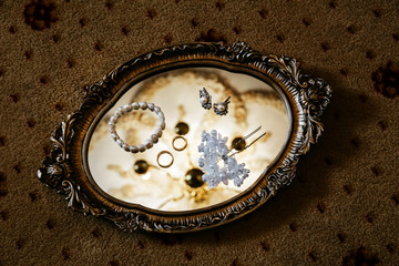 Pearl jewelry placed on a golden mirrored plate.