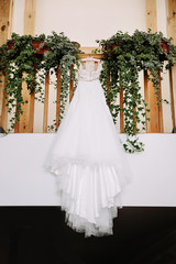 Beautiful white wedding dress hanging in stairway. 