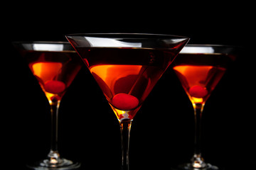 Closeup three manhattan cocktails in bar on black table