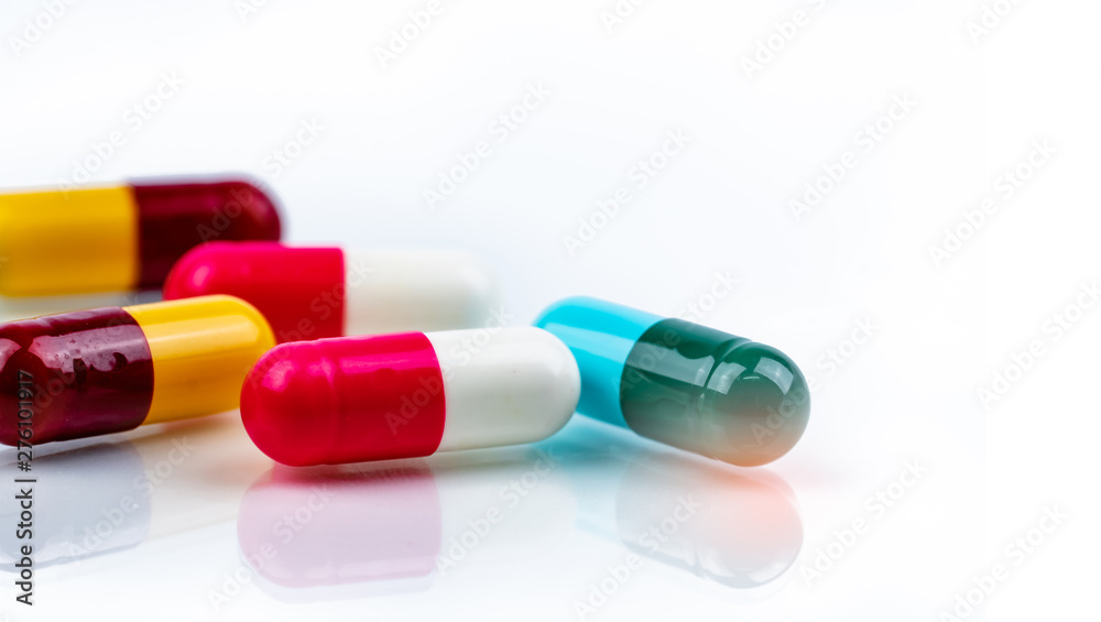 Wall mural colorful antibiotics capsule pills on white background. antibiotic drug resistance. pharmaceutical i