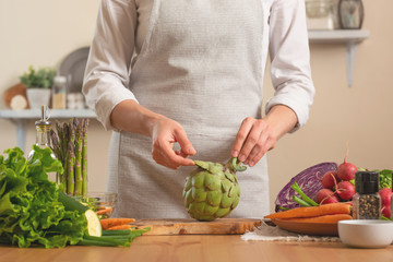 Chef preparing artichoke. The concept of losing healthy and wholesome food, detox, vegan eating, diet, cooking. Slow food, comfort food, healthy diet, clean eating, horizontal photo