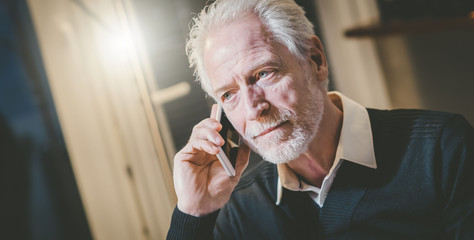 Portrait of senior modern man talking on mobile phone