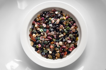 Stone beads from tourmaline in a white plate.