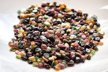 Tourmaline stone beads on white background.