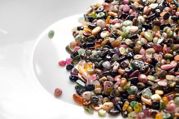 Tourmaline stone beads on white background.