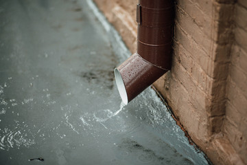 Rainwater flows out of the drainpipe