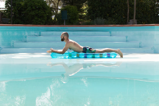 Urlauber in einem leeren Pool mit einer Luftmatratze 