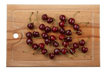 Naklejka na ściany i meble Ripe red cherry on a cutting wooden board.