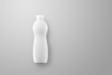 Blank curved plastic bottle with reflections and shadows on a gray studio background.
