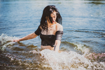 Vacation time. Woman in black swimsuit  at summer days 