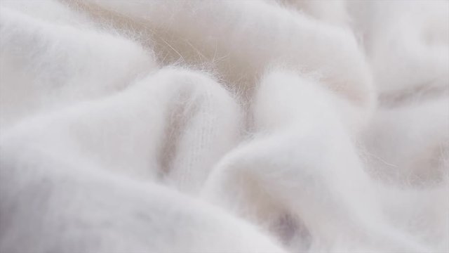 Soft wool background. Alpaca wool mohair clothes texture closeup. Natural cashmere fluffy merino wool. Woolen fabric. Rotation. 4K UHD video footage. 3840X2160